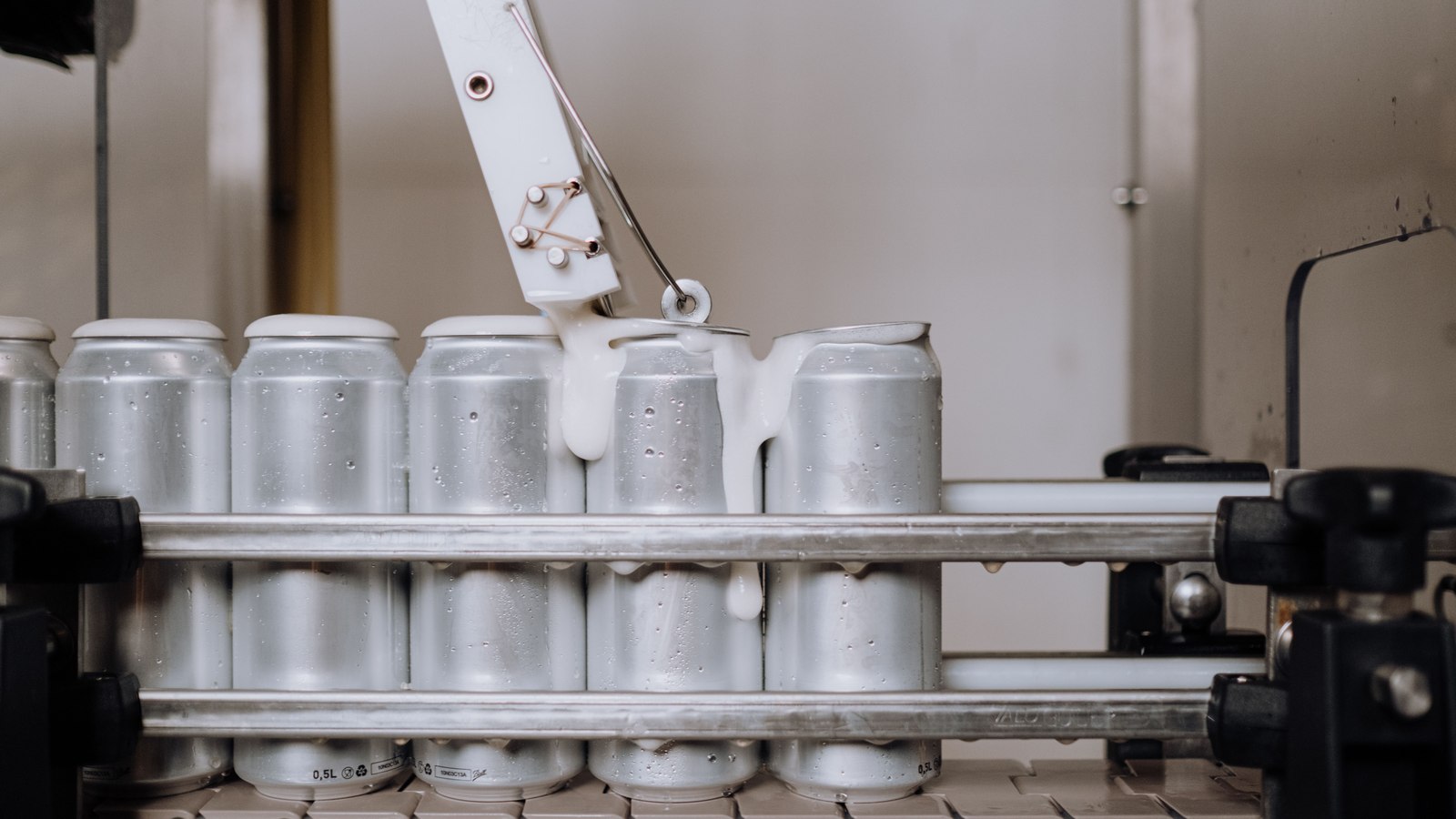Latas de aluminio recién selladas en una línea de llenado industrial