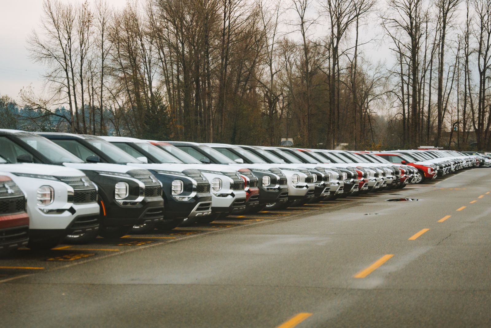 Hilera de SUV 0km recién llegados estacionados en un patio de concesionaria