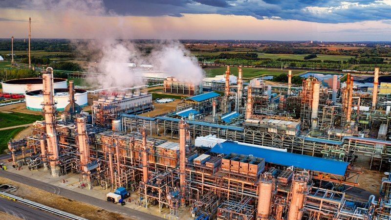 Refinería de petróleo vista desde arriba, con tanques blancos y estructuras de tuberías
