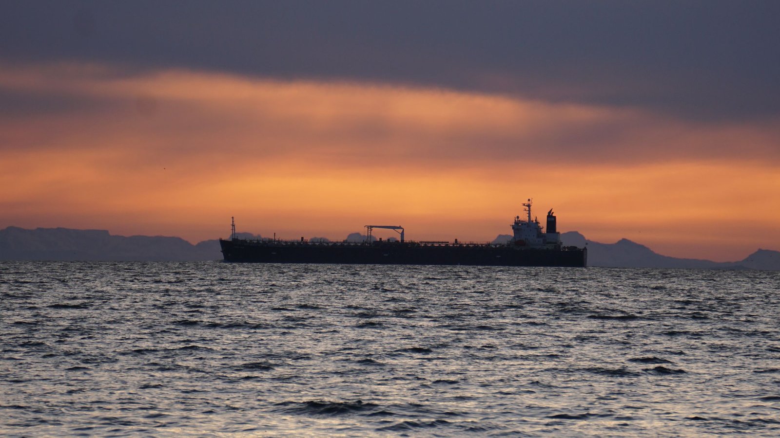 Petrolero navegando en el horizonte bajo un cielo cargado