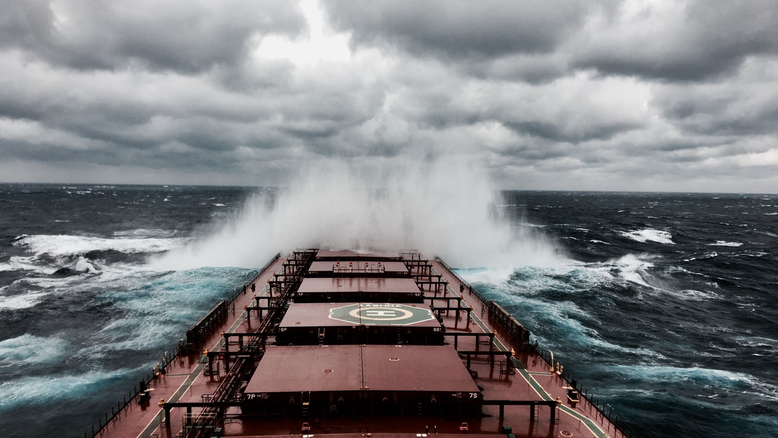 Vista desde la cubierta de un buque de carga golpeado por olas grandes en medio de una tormenta en el mar