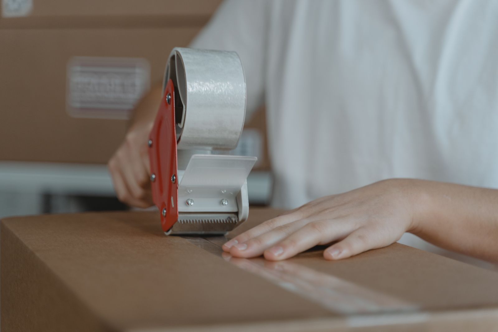 Paquete chico siendo embalado con cinta para envío por courier aéreo